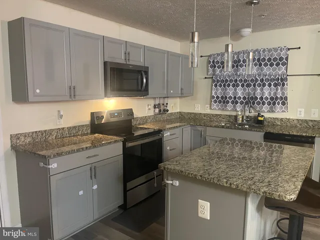 a kitchen with a sink stove and microwave