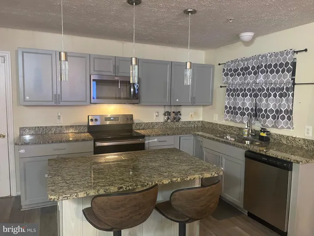 a kitchen with a stove a sink and a refrigerator