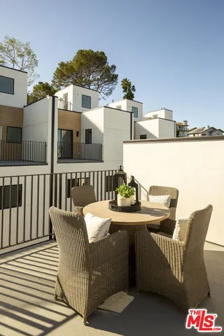 a balcony with table and chairs