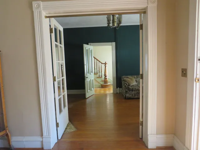 a view of a hallway with wooden floor and closet