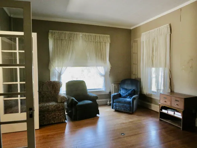 a view of a livingroom with a window and wooden floor