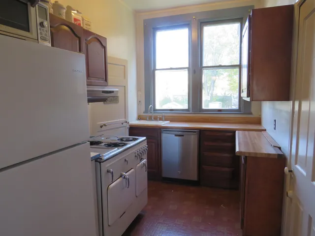 a kitchen with granite countertop a sink stove and cabinets