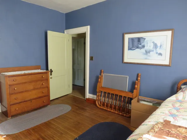 a bed sitting in a bedroom next to a window with kitchen