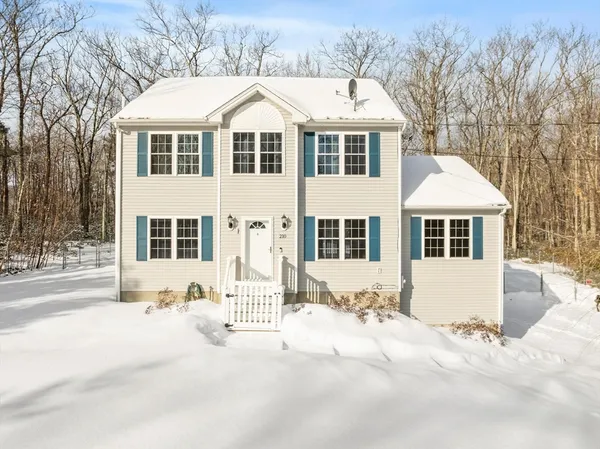 a front view of a house with a yard covered in snow