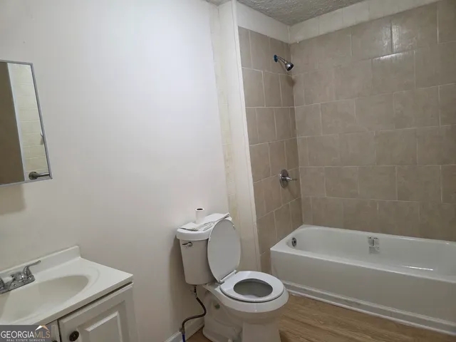 a white toilet sitting next to a bath tub