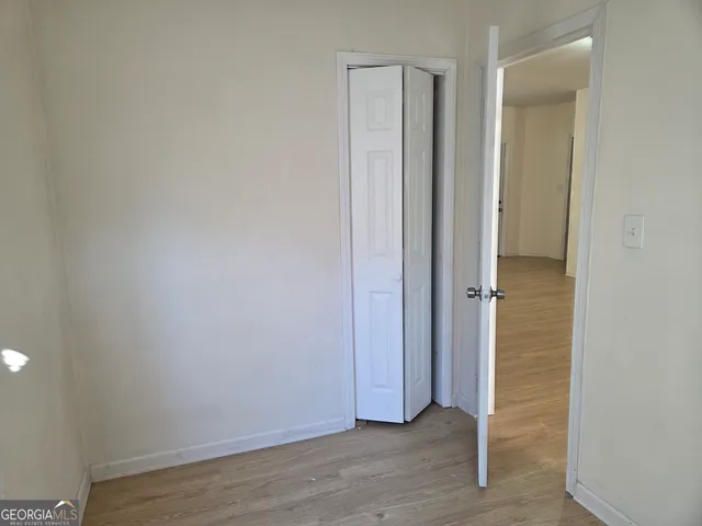 a view of empty room with wooden floor