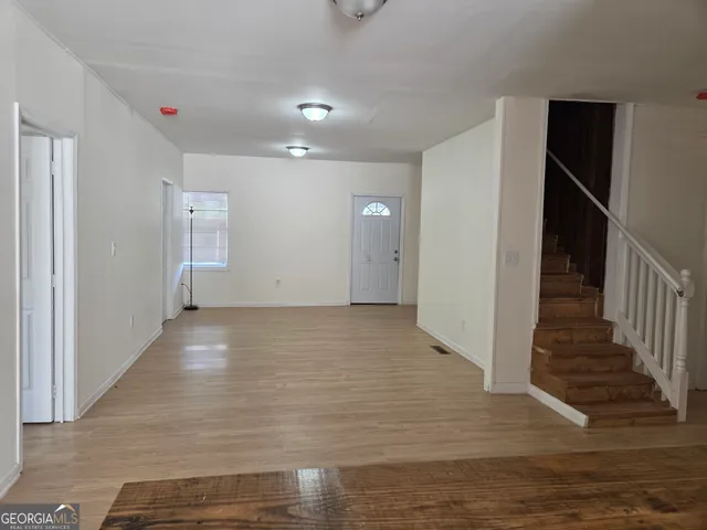 a view of a hallway with wooden floor and entryway
