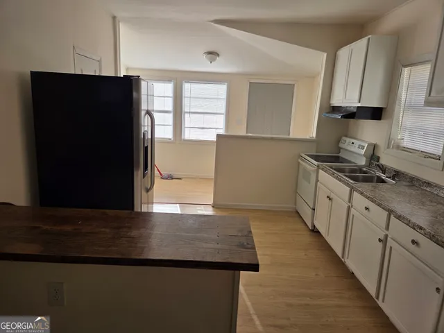 a kitchen with granite countertop a refrigerator and a sink