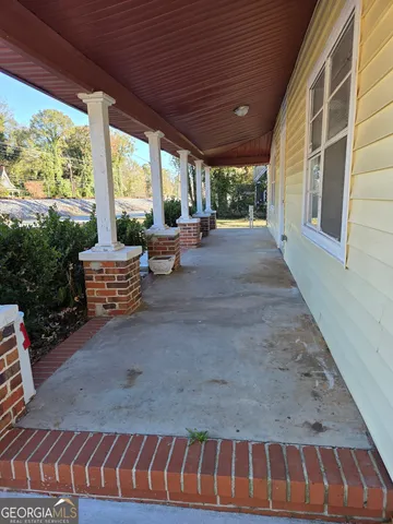 a view of patio with a table and chairs and potted plants
