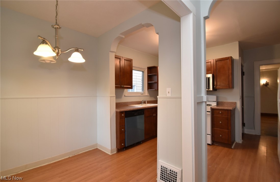 1135 Plainfield Road Cleveland, OH 44121 - Photo 13 of 32 Kitchen with a chandelier, light hardwood / wood-style floors, decorative light fixtures, and sink