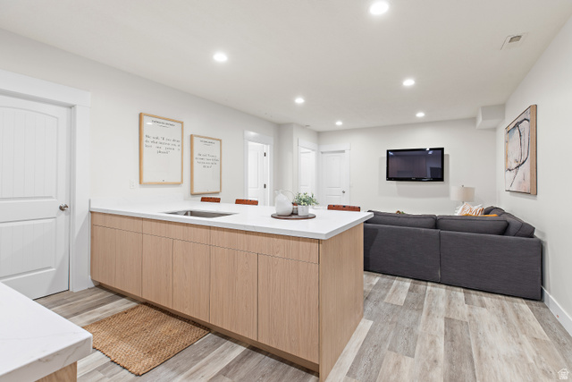 912 North Loafer Canyon Road Elk Ridge, UT 84651 - Photo 40 of 98 Open concept living space featuring wood-finish flooring, recessed lighting, a kitchen island with light wood-finish cabinetry, and a built-in stainless steel sink