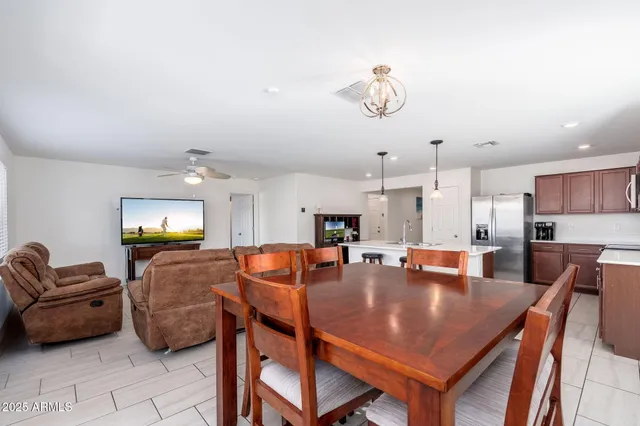 a dining room with wooden floor a chandelier a wooden table and chairs