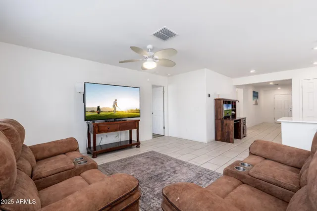 a living room with furniture a ceiling fan and a rug