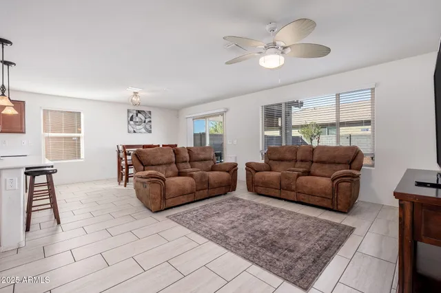 a living room with furniture and a ceiling fan