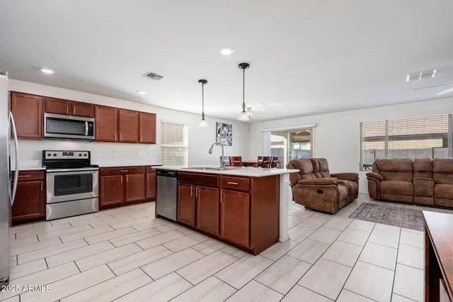 a large kitchen with stainless steel appliances granite countertop a stove and a sink