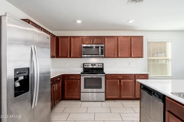 a kitchen with stainless steel appliances granite countertop a stove a sink and a refrigerator