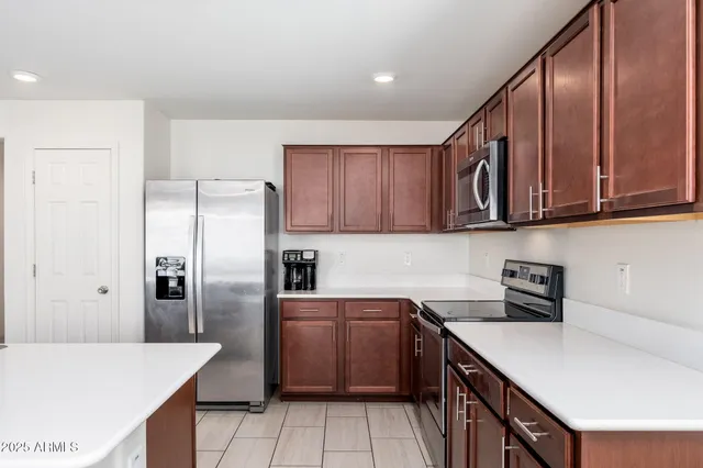 a kitchen with a sink a refrigerator and cabinets