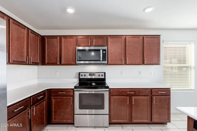 a kitchen with granite countertop wooden cabinets and stainless steel appliances