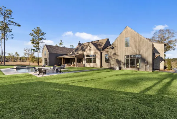 a view of a house with a big yard and large trees