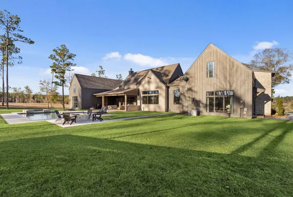 a view of a house with a big yard and large trees