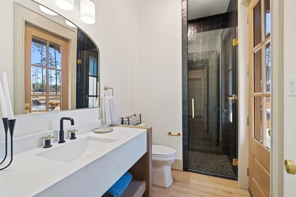 a bathroom with a sink a toilet and shower