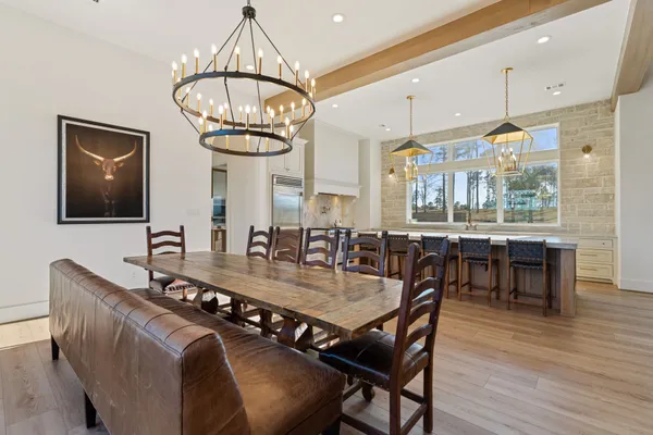 a dining room with furniture a chandelier and wooden floor