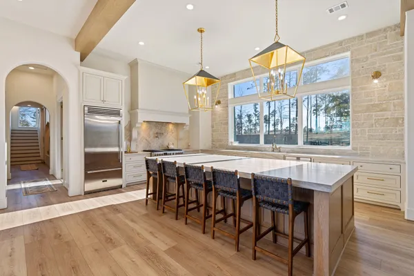 a dining room with wooden floor a chandelier a wooden table and chairs