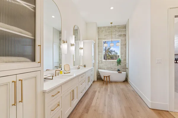 a spacious bathroom with double vanity and a bathtub