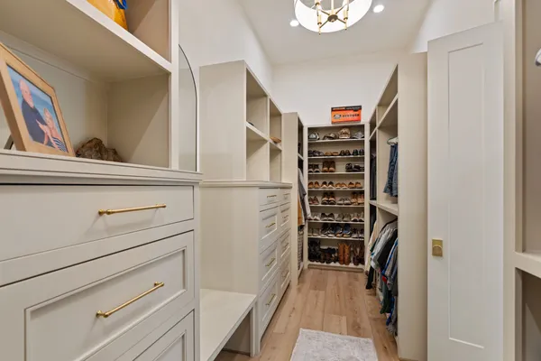 a view of walk in closet with clothes and shoes