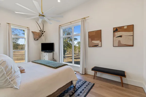 a bedroom with a bed a flat screen tv and a window