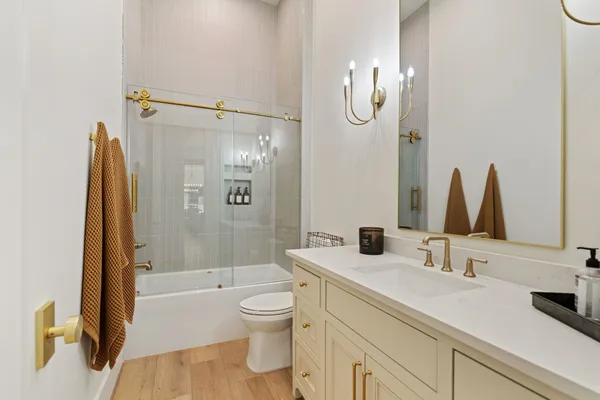 a bathroom with a granite countertop sink a toilet and shower