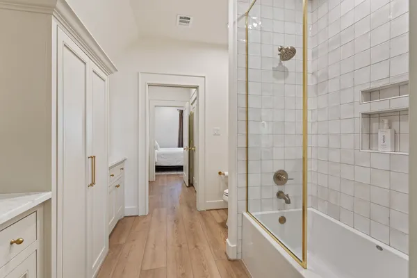 a bathroom with a tub shower vanity and a sink