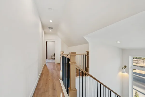 a view of a hallway with wooden floor and entryway