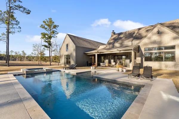 a view of a house with swimming pool and sitting area