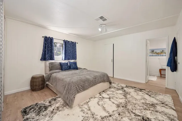 a bedroom with a bed and wooden floor