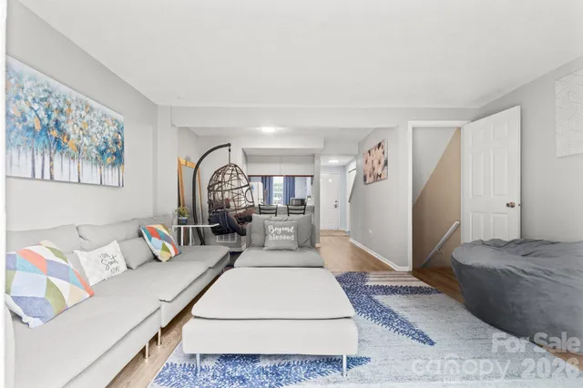 a view of a hallway with wooden floor and a bathroom