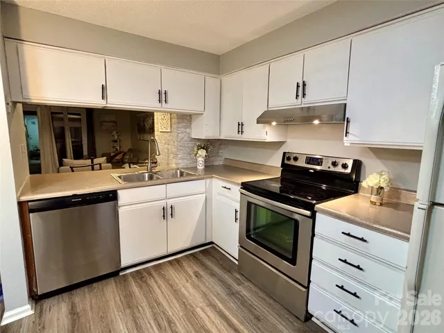a view of a hallway with bathroom and wooden floor