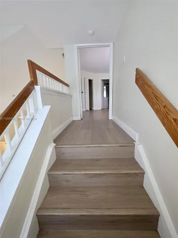 a view of staircase with white walls and railing
