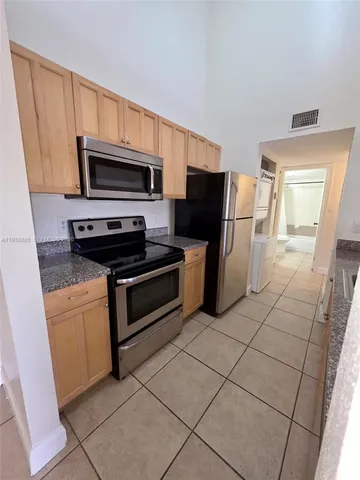 a kitchen with stainless steel appliances a stove a microwave and a sink