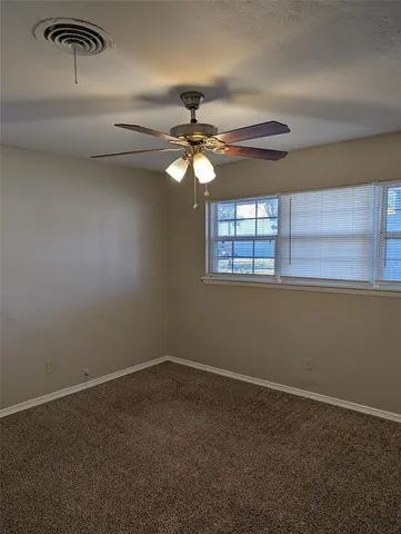 a view of a livingroom with a ceiling fan and window