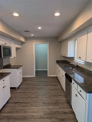 a kitchen with granite countertop a stove and a sink