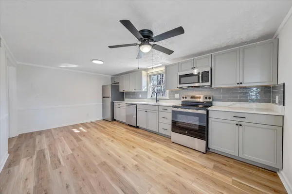 a kitchen with cabinets stainless steel appliances and a window