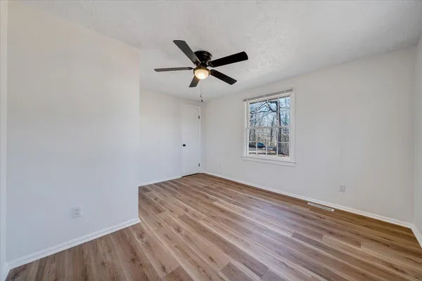 a view of empty room with wooden floor