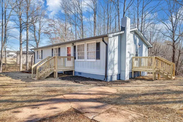 a view of a house with a large tree in front of it