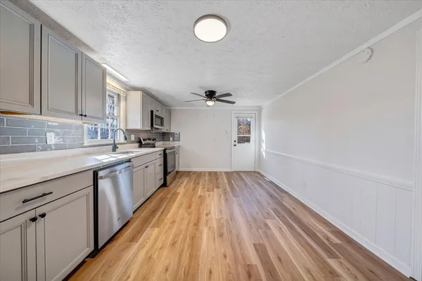 a kitchen with wooden floors and white cabinets