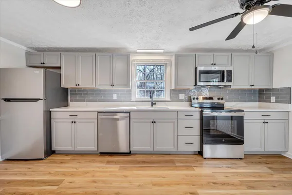 a kitchen with stainless steel appliances granite countertop a stove a sink and a refrigerator