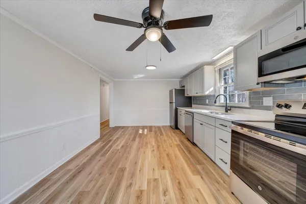 a kitchen with granite countertop a sink stainless steel appliances and cabinets