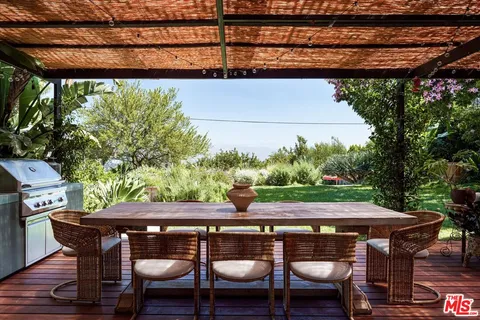 a dining area with furniture a rug and a chandelier