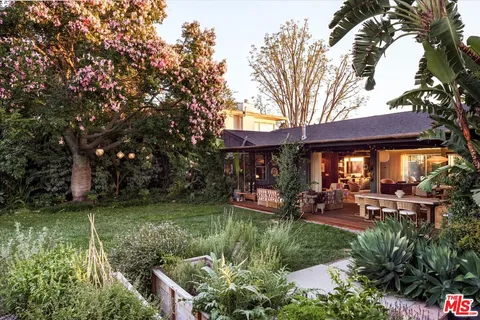 a backyard of a house with yard table and chairs