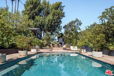 a patio with a table and chairs under an umbrella